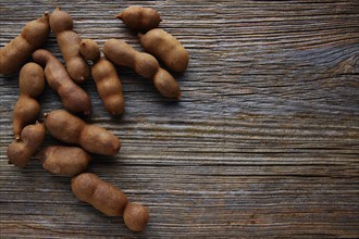 Tamarindo tamarind fruits ripe on brown wood background uses for candy