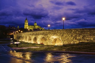 Salamanca skyline sunset and roman bridge over Tormes river in Spain