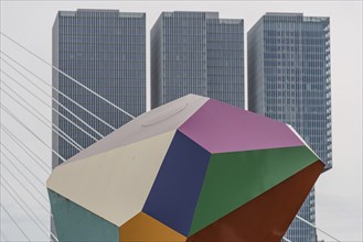 Colourful artwork in front of modern skyscrapers and bridge cables, rotterdam, the netherlands