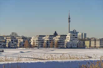 View of the snow-covered and frozen Phoenix Lake and the Florian television tower in Dortmund,