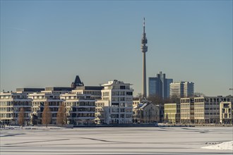 View of the snow-covered and frozen Phoenix Lake and the Florian television tower in Dortmund,