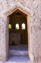 Open entrance to a small building with a view, in the largest preserved mud town in Oman, Al