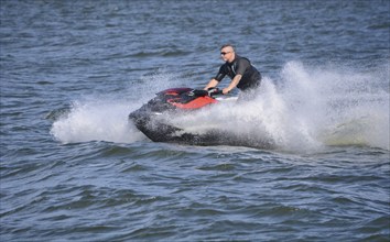 Man on jet ski, water scooter on Baltic Sea, Swinoujscie, Western Pomerania, Poland, Europe