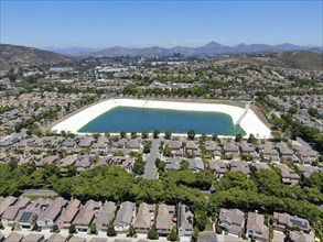 Aerial view of water recycling reservoir surrounded by suburban neighborhood in San Diego County,