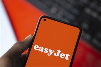 EasyJet logo is displayed on smartphone. EasyJet plc is a British multinational low cost airline