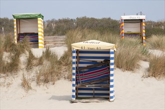 Three beach chairs on sandy dunes, surrounded by grasses, quiet coastal atmosphere, Borkum, l North