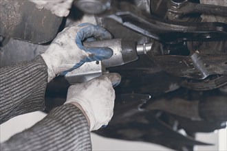 Hands of car mechanic in auto repair service