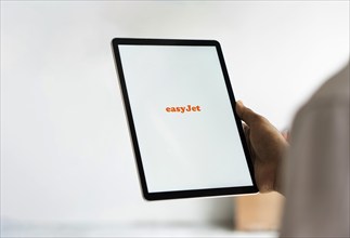 EasyJet logo is displayed on iPad. EasyJet plc is a British multinational low cost airline group.