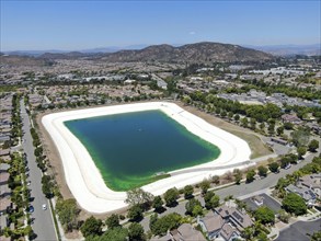 Aerial view of water recycling reservoir surrounded by suburban neighborhood in San Diego County,