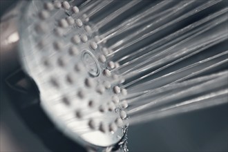 Shower head with flow of water spilling out closeup. Modern shower head splashing water close up