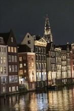 Night scene of a canal with illuminated house facades and reflections, Amsterdam, Netherlands