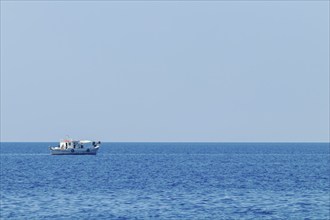 Fishing boat floating on the water, blue sea and sky