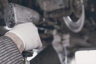 Hands of car mechanic in auto repair service