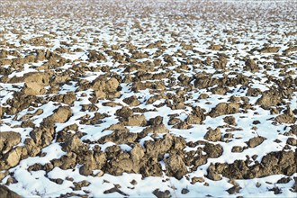 Melting snow on plowed soil. Spring view of plowed field