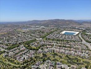 Aerial view of water recycling reservoir surrounded by suburban neighborhood in San Diego County,