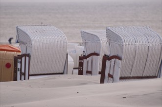 Empty beach chairs stand in a row overlooking the calm sea, Borkum, North Sea, GERMANY