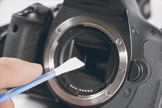 Cleaning dirty camera sensor. Digital photo camera with cleaning tools