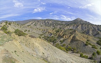 Clay ravines at the foot of the mountains. On the slopes of ravines one can see the structure of