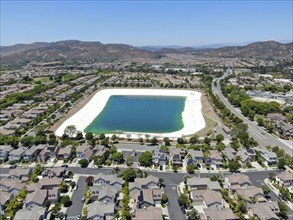 Aerial view of water recycling reservoir surrounded by suburban neighborhood in San Diego County,