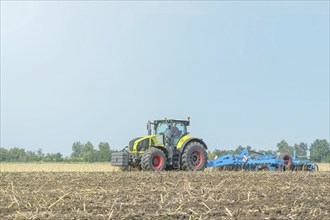 Farmer in tractor preparing land seedbed cultivator. Agriculture tractor landscape