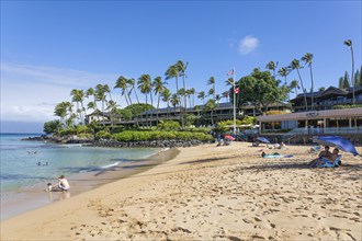 Tourist enjoying tropical beach with white sand and crystal clear water in Maui, Hawaii, USA,