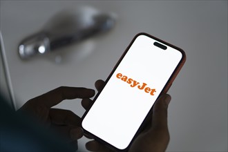 EasyJet logo is displayed on smartphone. EasyJet plc is a British multinational low cost airline