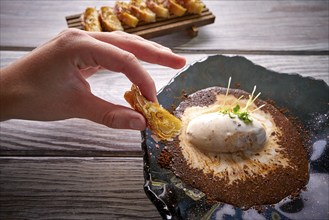 Hand holding pastry on Ice cream dessert with milk and coffee