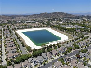 Aerial view of water recycling reservoir surrounded by suburban neighborhood in San Diego County,