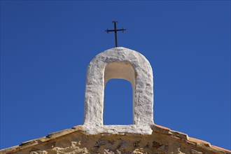 Christian cross on whitewashed arch at village church in Cuenca Spain