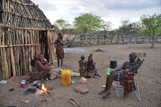 Chief Hikuminue Kapika, chief of the Namibian Himba, with his family at the fire in his kraal,