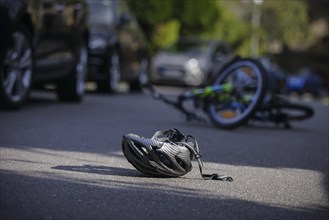 Symbol photo on the subject of bicycle accidents (posed scene) . A broken bicycle helmet lies next