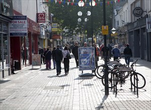 Busy pedestrianised shopping street in the town centre of Swindon, England, UK