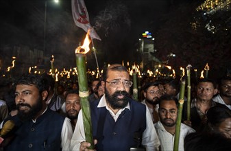 Members of the All Assam Students' Union (AASU) take part in a flaming torch rally and shout