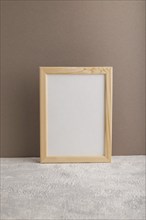 White wooden frame mockup on beige paper background. Blank, vertical orientation, still life, copy