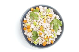 Pearl barley porridge with vegetables in blue ceramic bowl isolated on white background. Top view,