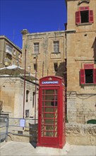 Red telephone box booth in historic city centre of Valletta, Malta, Europe