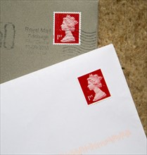 Looking down at letters in envelopes with red First class postage stamps, England, UK