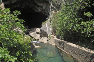 Person exploring entrance ot cave, Cueva del Gato, Benaojan, Serrania de Ronda, Malaga province,