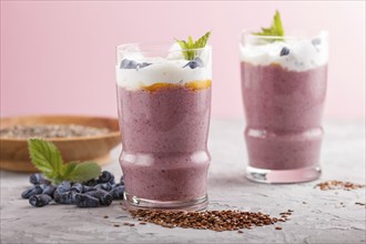 Smoothie with honeysuckle, linen and chia in a glass on gray concrete background. side view, close