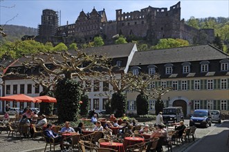 View of Heidelberg Castle as seen from Karlsplatz Café with guests in front, Karlsplatz,