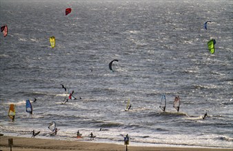 Kitesurfers and windsurfers in strong winds on the beach of Scheveningen, The Hague, Netherlands