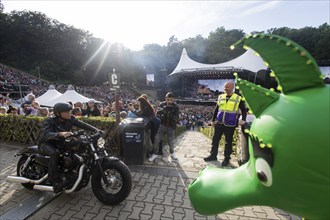 Peter Maffay rides past Tabaluga on his Harley Davidson in front of his concert on We Love Rock 'n'