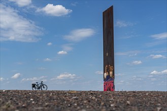 Cycling in the Ruhr area, on the Schurenbach slag heap, Bramme landmark for the Ruhr area by artist