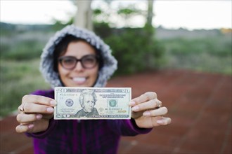 Happy Woman showing twenty dollar bill