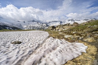 Picturesque mountain landscape with snow remains, mountain peaks with snow and glacier