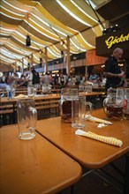 Empty beer mugs on a table in a large marquee during a party, Canstatter Wasen, Stuttgart, Germany,