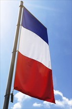 French national flag in front of a blue sky