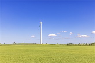 Wind turbines in the countryside with green fields in a rural landscape view