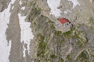 Aerial view of mountain hut Cabane de l'A Neuve, located on a steep rock formation, near La Fouly,