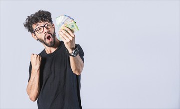 Winner man holding bills celebrating isolated. Concept of man earning money isolated